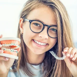 Una ragazza sorridente mostra un allineatore trasparente